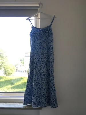 Söt klänning - Blommig klänning med snörning vid brösten. Bilden gör den inte rättvisa, sitter väldigt snyggt och tajt!