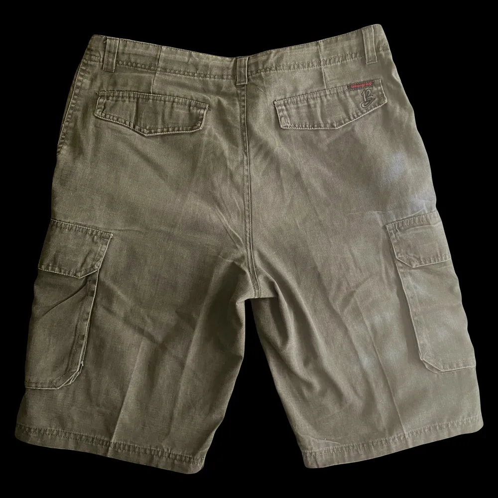 Vintage militärgröna cargo shorts, som är i bra skick. Skriv gärna innan ni köper. Midja 49 cm (går dock att justera med snörerna) Från gylfen till längst ner 39 cm.. Shorts.