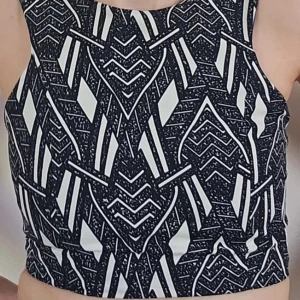 Kort, svartvit, mönstrad topp - Nu säljer jag min älskade svartvita, mönstrade topp som tyvärr är för liten för mig.   Den är kort, med dragkedja hela vägen baktill. Lite tjockare tyg så inte genomskinlig.   
