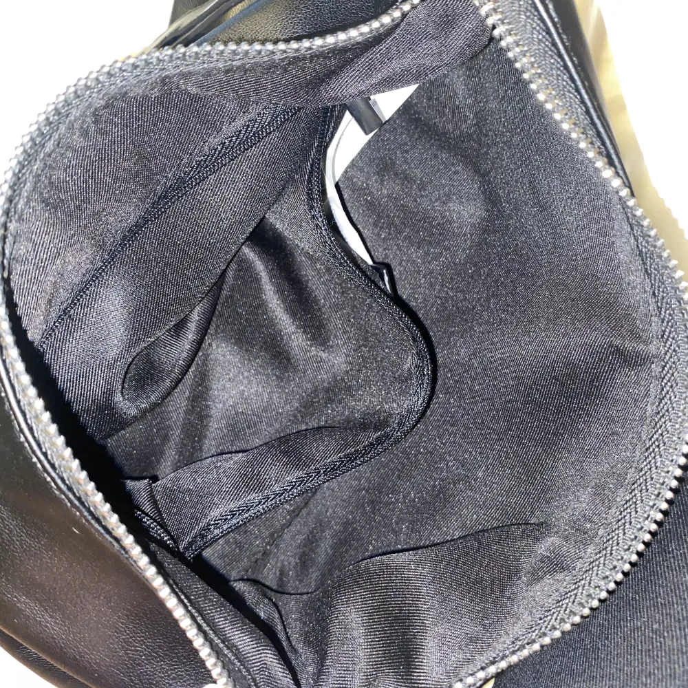 En super fin svart axelväska som tyvär inte kommer till användning. Väska har används en gång. Väskan är mjuk i materialet och i fake läder. Den har ett stort fack och ett mindre som förlita med dragkedja. Den är inte supper stor men rymmer endå en del. . Väskor.