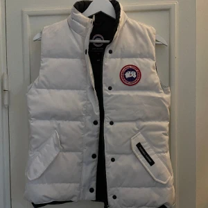 Canada goose väst dam - Helt ny canada goose väst i dam i vit, strl XS.  Nyskick och otroligt fin!! Nypris runt 6000. 