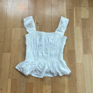 Vit volang topp - En vit volang topp med breda axelband, den är aldrig använd endast provad!