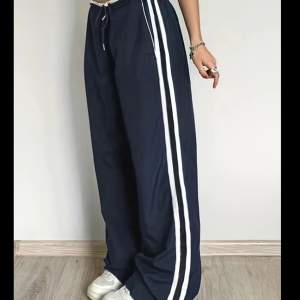 Ett par mörkblåa byxor som liknar Adidas trackpants. Säljer dem då de är lite för långa för mig men det är också en smak sak. Byxorna har band i midjan så det går att reglera. De har inga defekter då det är inprincip helt nya.