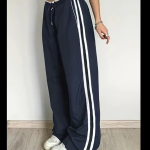 Blåa byxor - Ett par mörkblåa byxor som liknar Adidas trackpants. Säljer dem då de är lite för långa för mig men det är också en smak sak. Byxorna har band i midjan så det går att reglera. De har inga defekter då det är inprincip helt nya.