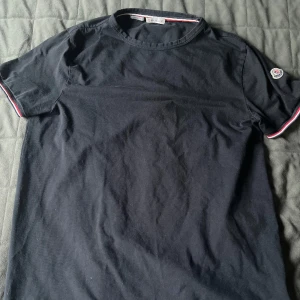 Moncler T-shirt  - En moncler t-shirt som är köpt på NK i Stockholm och används inte längre  Storlek L fast den är slim fit så passar till M