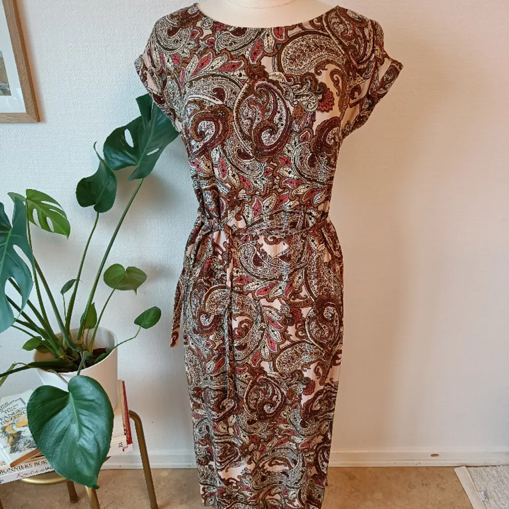 Vacker klänning med paisleymönster från Quiosque. Fint skick Storlek 36 Längd 119cm. Klänningar.