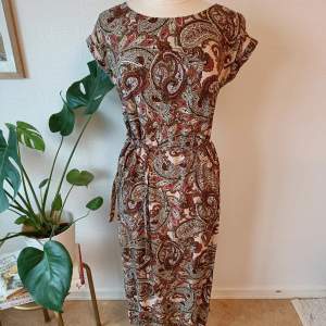 Vacker klänning med paisleymönster från Quiosque. Fint skick Storlek 36 Längd 119cm