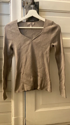 Ribbstickad långärmad - Söker denna ribbstickade långärmade tröjan. På bilderna ser den typ brun ut men den är egentligen grå/grön. Tröjan är lite nopprig