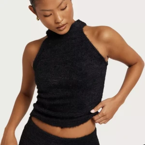 Svart lurvigt linne - Säljer detta svarta lurviga linne med halterneck från Nelly då den är för liten för mig. Den är helt ny, endast provad en gång! Hör av er för frågor! 🤍🤍