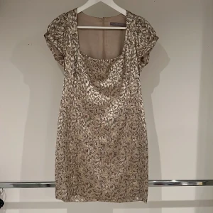 Tiger klänning i guldlyster  - Fortsätter med katttemat 🐈😻fast nu är det en klänning av märket Tiger. Tight klänning med liten puffärm och som slutar mitt på låret. Väldigt fin tycker både jag och matte. 😻