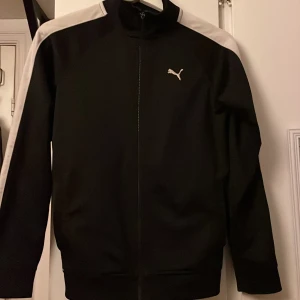 Puma jacka i nylon  - Fin nylonjacka från Puma  Storlek M i junior storlek  Dragkedjan fungerar utmärkt men dragtappen saknas. 