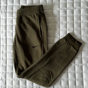 Nike mjukis - Ett par mossgröna mjukisbyxor från NIKE i S dammodell. Mjukisbyxorna har stören i midjan vilket gör dem extra justerbara 
