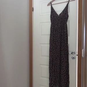 Långklänning - Svart långklänning med fina blommor som detalj. Passa till typ allt, fest, skola, middag, konsert! 