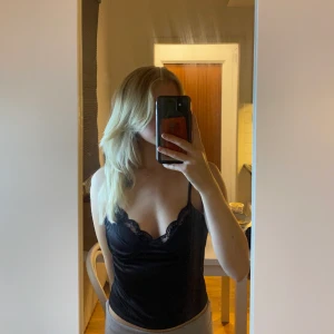 Festtopp Svart - Svart festtopp i silkesmaterial som tyvärr har blivit för liten. Använd mycket då det har varit en stor favorit hos mig, men den är inte sliten och har inga skavanker. Köpt från BikBok.