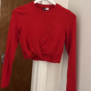 Långärmad topp - Croppad långärmad topp med fin ”draperingsdetalj” från H&M. Använd men i gott skick!