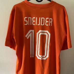 Sneijder VM 2014 - Sneijder tröja i Nederländerna från VM 2014. Stadium version. Självklart äkta. Skick 9/10, inga synbara fel. Skriv vid frågor eller för fler bilder! Bättre bilder kan fås det är Plick som zoomar bilderna i annonsen. 