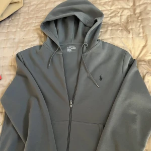 Ralph Lauren Hoodie  - Säljer min mörkgrå Ralph lauren Hoodie som i princip är i nyskick, ett tag sen jag köpte den så har inget kvitto. Priset är inte skriver i Sten så är öppen för prisförslag!