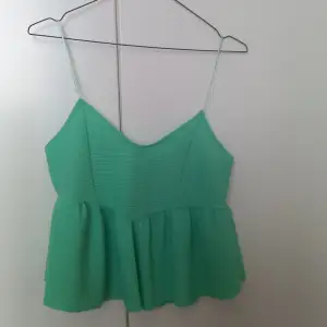 Green, short top with a zipper on the other side. 