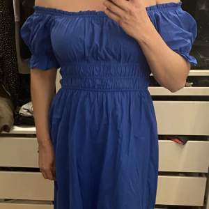 Off shoulder klänning från H&M (aldrig använd), ankellång i storlek M. Färg: Blå  Plagget finns i Ursvik, Sundbyberg om du önskar hämta det.
