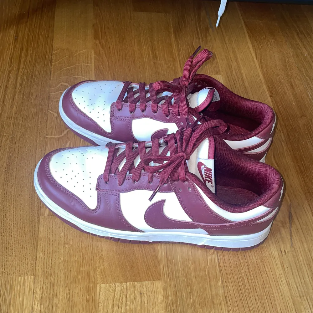 Nike low dunks i red Bordeaux färgen, storlek 41. Endast använda ett par få gånger. . Skor.
