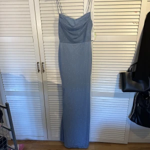 Balklänning - Superfin blå silverglittrig balklänning. Prislappen kvar, aldrig använd. Nypris 65$ ~ 700kr Storlek L men passar mig som har S/M