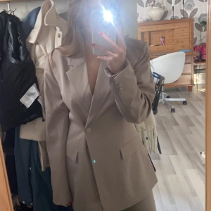 Lojsan Wallin blazer - Helt oanvänt. Säljer både kostymbyxan och blazern.  Modell: straight fit trousers ordinarie pris  399  Modell: singel button blazer ordinarie pris 699 Storlek 38 i både.   Säljer 700 kr för båda  Färg Dark Greige