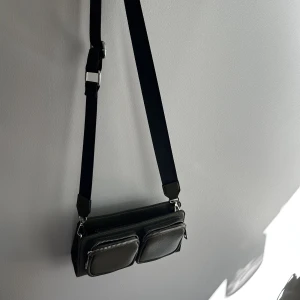 Väska - Jättefin olivgrön väska från NA-KD som ser så bra ut till så mycket och med mycket utrymme och olika fack, ett brett axelrems band men så snyggt, jätte fin nu till hösten 🍸🫒köparen står för frakt