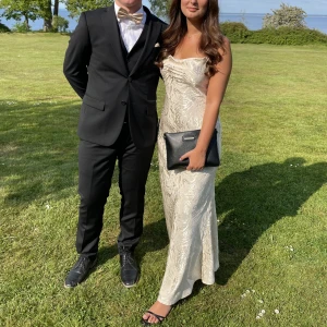 Balklänning - Säljer min balklännning som endast är använd en gång. Den är champange färgad o har ett zebra likt mönster i satin. Inga defekter. Storlek xs men passar även s. Är 162 lång. OBS den är ej struken på de två sista bilderna. Köparen står för frakten!