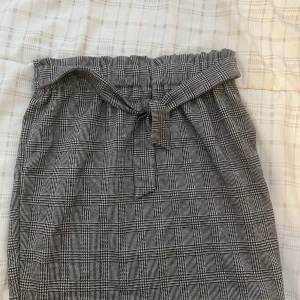 Plädkjol  - En supergullig plädkjol med rosett. Storleken är 146/152cm (barn) men den fungerar också att använda om man är en kortare vuxen. (Jag är 155cm) 