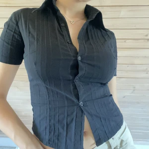 Svart topp/ blus - Väldigt formgivande topp, köpt på second hand i Helsingfors. Står M men är mer en S