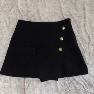Kjol med shorts - En superfin o classy kostymaktig kjol som är shorts på baksidan från Zara. Har guldiga knappar där bak o fram + en ficka på framsidan   Kanske svårt att fatta så skriv för bilder💕 Passar 34-36