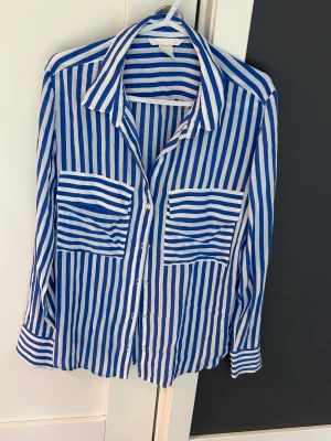 Sjorta - Randig skjorta från H&M i blåvit färger. Mjuk och bekväm material som är använd 2 gånger. Normal i storlek. 