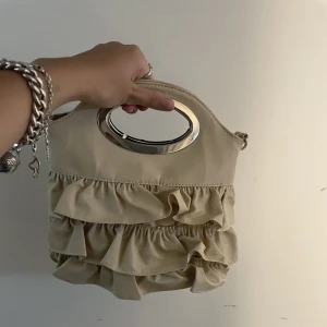 Väska - Väldigt snygg väska med volanger, band medföljs (3e bilden). 