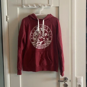 Röd huddie  - Röd huddie, freds gudinna som tryck med text där det står N.Y.C Nex York. Är storlek M men tycker att det mer är S. 60% Cotton 40 % polyester 