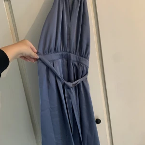 Klänning  - Jättefin blå sidenklänning köpt i Schweiz. Svårt att fånga på bild men jättefin klänning med markerad midja med ett sidenband och tunna band vid halsen. Storlek Xs