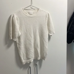 Vit stickad T-shirt  - Här är en söt vit stickad T-shirt, den är inte så använd ungefär 2-5 gånger alltså väldigt bra skick😊