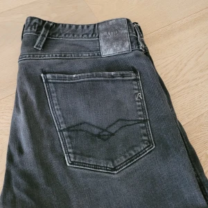 Replay anbass jeans - Ett par riktigt feta replay jeans i mörkgrå färg perfekta för stockholmsstilen. Har en liten lagning (se bild 2) därav det låga priset!