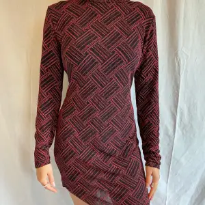 Glittrig röd klänning i zackat mönster. Använd 2ggr. Tajtare modell med stretchigt material. Storlek XL.