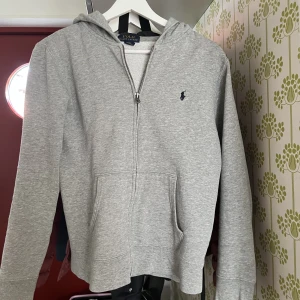 Polo Ralph Lauren Zip Hoodie - Storlek XS (14-16), säljer då den är för liten. 10/10 nyskick ej använd. Nypris ca 1600 mitt pris 699. Är även öppen för byten. Skriv vid minsta fundering!