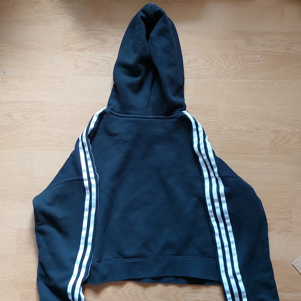 Snygg croppad Adidas hoodie perfekt inför våren och de kyligare sommardagarna. Den är i bra skick! Strl: xs. Toppar.