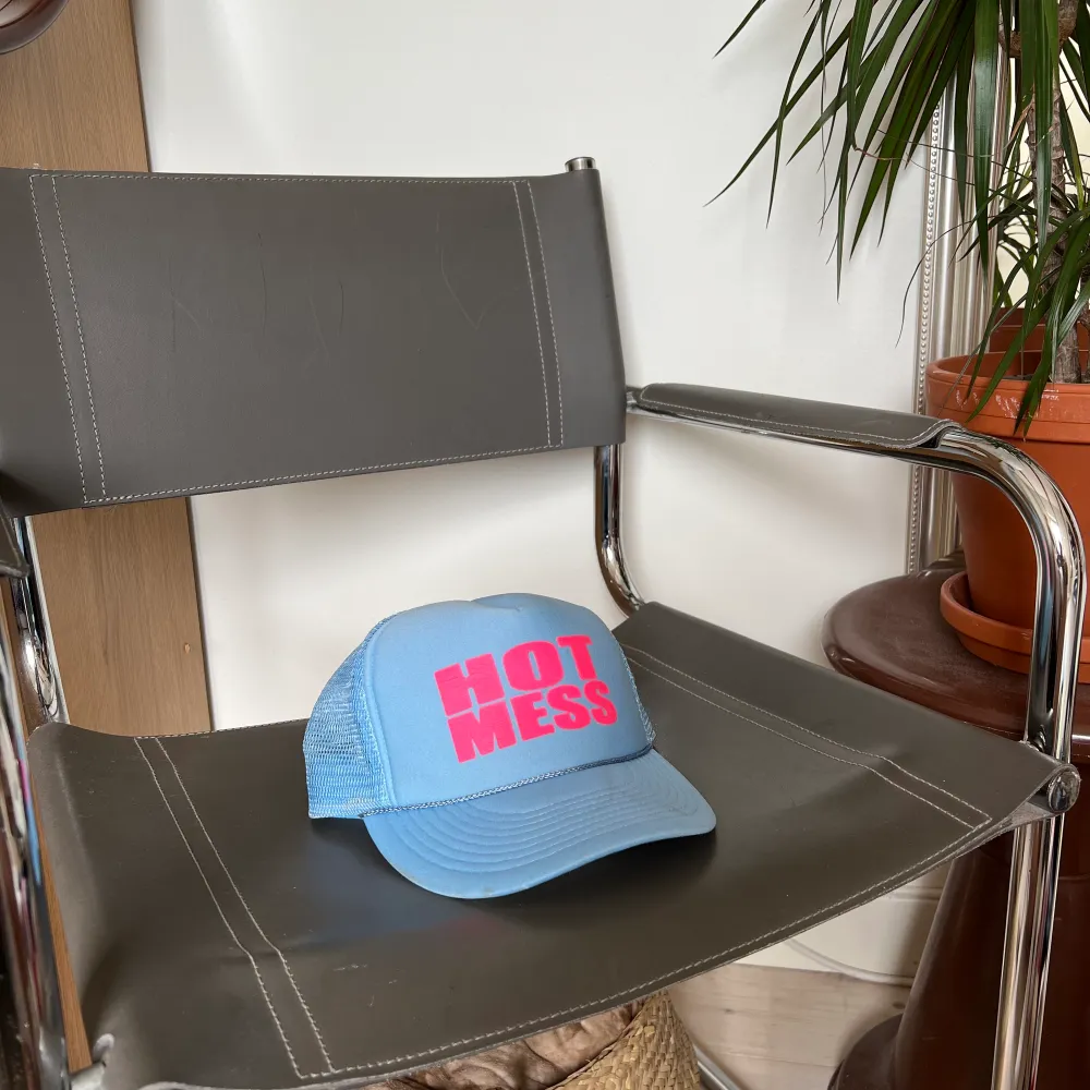 trucker hat in baby blue with pink text saying “hot mess”.   bought in the USA a couple of years ago. few signs of wear but nothing major. Övrigt.