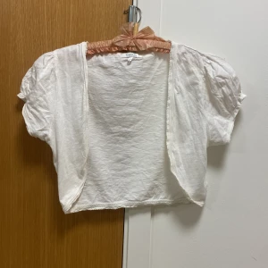 T-shirt tyg/ Vit bolero 🤍 - Vit söt bolero från Cubus. De står stl L men den passar en M. De är någon liten svag fläck på ena sidan, den kan ha kommit emot något på min vindsgarderob, tvättar innan den skickas. Annars jätte fin! Passar perfekt till studenten! 🤍