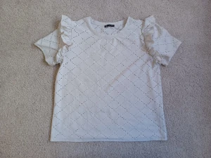 Topp från Zara. - Vacker vit topp med fina dekorativa detaljer vid axlarna. 