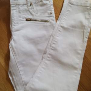 Vita jeans med dragkedjefickor fram och vanliga bakbyxor. Tajt modell. Oanvända  