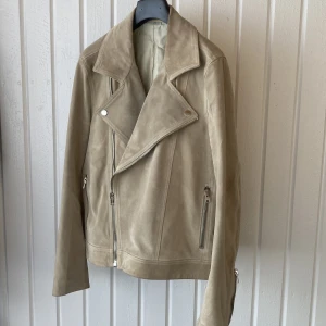 Skinnjacka  - Lyxig skinnjacka (mocka) från Whyred tillverkad i Italien.  Äkta skinn. Storlek 46 herr, liten i storlek. Fungerar givetvis bra som unisex.  Mycket fint skick men tyvärr en reva i innerfodret därav det låga priset.   Minns ej nypris, men runt 5-7 lax.