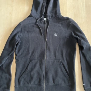 Svart CK Hoodie  - Svart Hoodie från Calvin Klein Jeans i befintligt skick. Storlek Xs