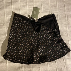 Kort kjol - Kort kjol i storlek S. Jättefint blommig tyg med prislappen kvar. Säljs så storleken är för liten. Går och ha både låg och högmidjad.