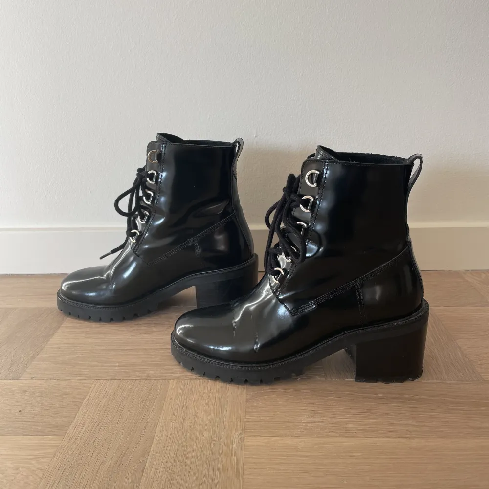 Svarta stövletter / booties från franska Maje. Svart, blankt läder med snörning och grövre sula. Klackhöjd ca 6 cm. Otroligt snygga men tyvärr för små, så enbart använda ett fåtal gånger. Nypris 3500kr för två år sen, knappt använda så i perfekt skick. Kengät.