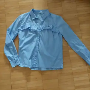 Blå skjorta från H&M, använd 2 gånger. Skjortan är i nyttskick.