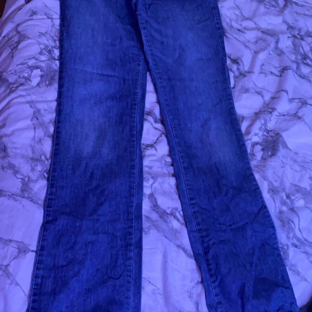 Ett par blå lågmidjade jeans som är för stora för mig som man kan se på bilden’. Jeans & Byxor.